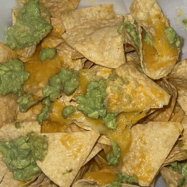 Close-up of Burrito Grande's nachos with melted cheese and dollops of guacamole.