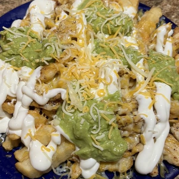 Burrito Grande's Mexican fries topped with guacamole, sour cream, and shredded cheese.