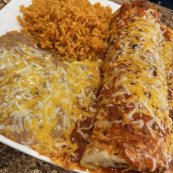 A plate of Burrito Grande's cheesy enchiladas, refried beans, and Mexican rice.